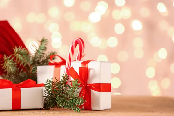 Karácsonyi Ajándékok Fenyőágak Asztalon Homályos Fények Ellen — Stock Fotó