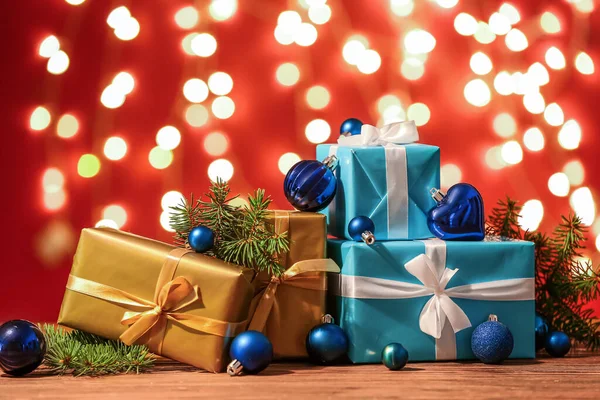 Veel Kerstgeschenken Decoraties Sparren Takken Tafel Tegen Wazig Licht — Stockfoto