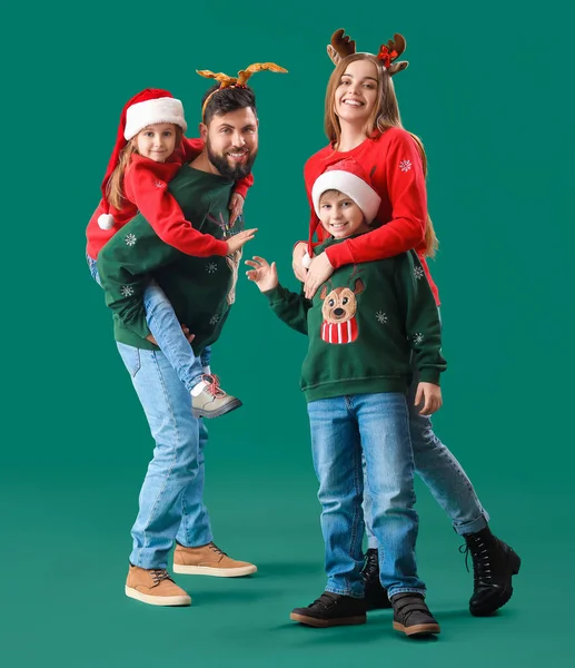 Happy family in Christmas clothes on green background