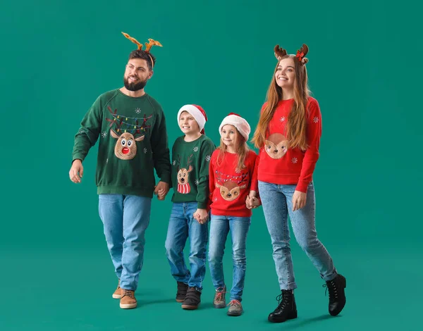 Ευτυχισμένη Οικογένεια Χριστουγεννιάτικα Ρούχα Κρατώντας Χέρια Στο Πράσινο Φόντο — Φωτογραφία Αρχείου