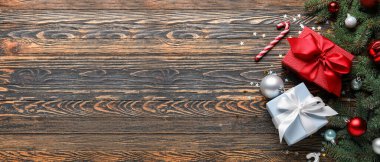 Noel hediyeleriyle kompozisyon, köknar dalları ve tahta arka planda metin için alanı olan dekorasyonlar