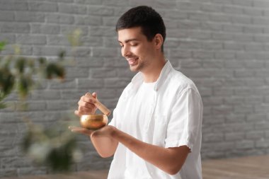 Tibet şarkı kasesi olan genç bir adam.