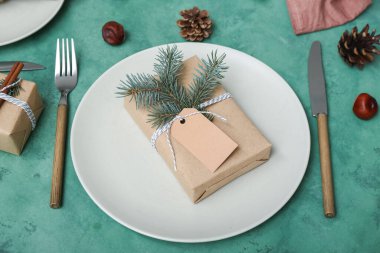 Noel hediyeli güzel bir masa, yeşil arka planda köknar dalları ve koniler, yakın plan