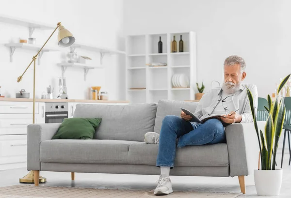 Senior Bearded Man Reading Magazine Sofa Kitchen — Stock Photo, Image