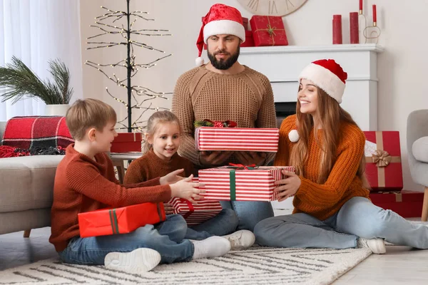 Glada Föräldrar Tomte Hattar Och Deras Små Barn Med Julklappar — Stockfoto