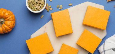 Mavi arka planda lezzetli balkabağı turtası parçaları.