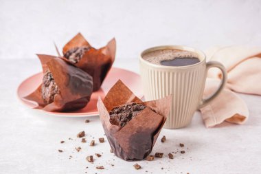 Tatlı çikolatalı kekler ve arka planda bir fincan kahve.