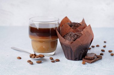 Nefis çikolatalı kekler ve arka planda bir fincan kahve.