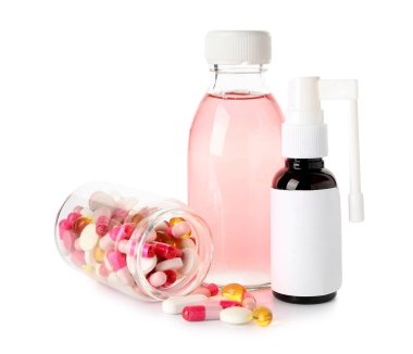 Boğaz ağrısı için sprey, öksürük şurubu ve beyaz arka planda haplar.