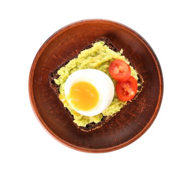 Beyaz arka planda haşlanmış yumurta ve avokado ile bir tabak lezzetli tost.