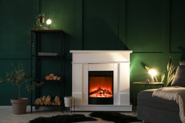 Şömineli, parlak lambalı ve raflı karanlık oturma odasının içi.