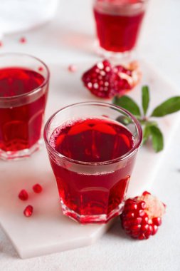 Hafif arka planda lezzetli nar suyu bardakları, yakın plan.