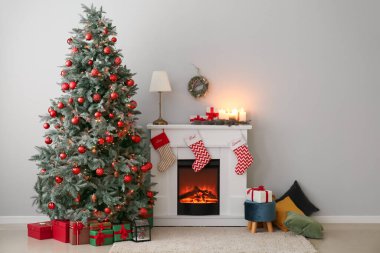 İçinde şömine, hediyeler ve Noel ağacı olan oturma odası.