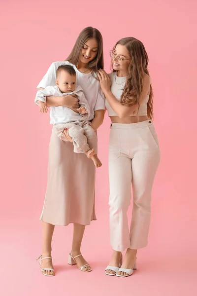Feliz Pareja Lesbiana Con Pequeño Bebé Sobre Fondo Rosa — Foto de Stock