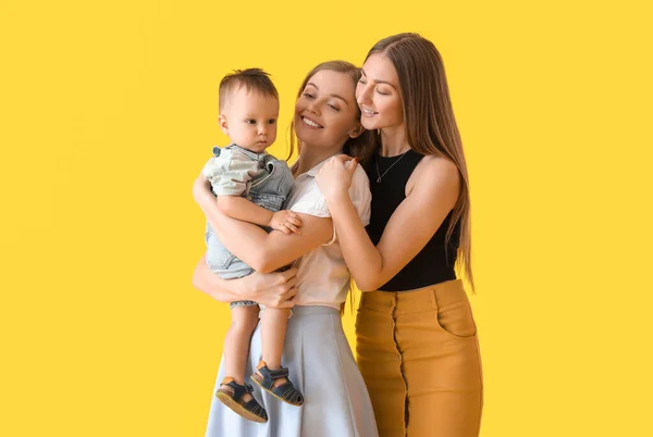 Glückliches Lesbisches Paar Mit Baby Auf Gelbem Hintergrund — Stockfoto