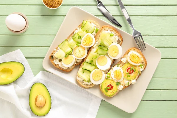 stock image Plate of tasty toasts with boiled egg on color wooden background