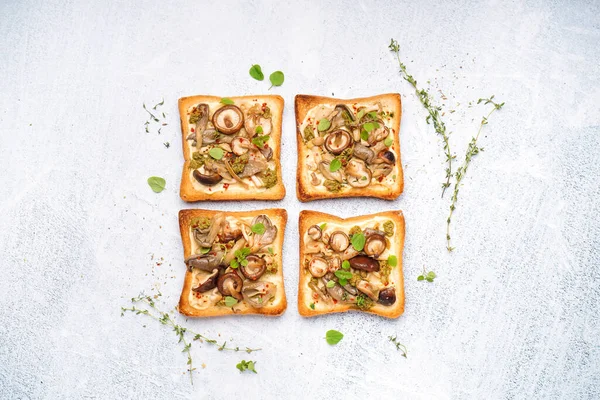 stock image Delicious toasts with cream cheese, mushrooms and pesto sauce on light background