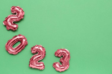 Yeşil arka planda folyodan yapılmış 2023 şekli