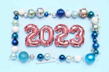 Şekil 2023 balonlardan ve farklı renk arkaplanlı Noel toplarından yapılmıştır.