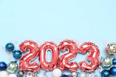 Şekil 2023 balonlardan ve farklı renk arkaplanlı Noel toplarından yapılmıştır.