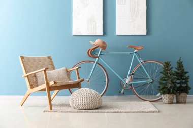 Oturma odasının içinde bisiklet, koltuk ve küçük köknar ağaçları var.