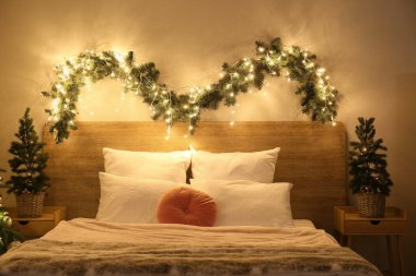 Parlayan Noel ağaçları ve köknar dallarıyla dolu yatak odasının içi