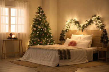 Parlayan Noel ağaçları ve köknar dallarıyla dolu yatak odasının içi
