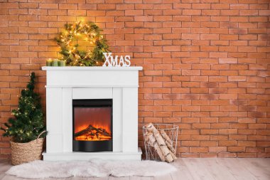 Parlak çelenkli şömine, Noel ağacı ve tuğla duvarın yanında yakacak odun.