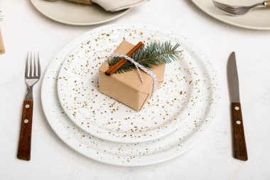 Beyaz arka planda köknar dalı ve tarçın olan Noel sofrası, yakın plan