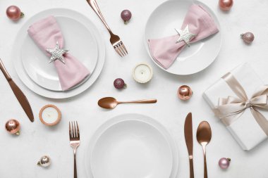 Beyaz arka planda Noel baloları, hediyeler ve mumlarla dolu güzel bir masa.