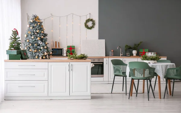 有圣诞树 柜台和餐桌的厨房的内部 — 图库照片