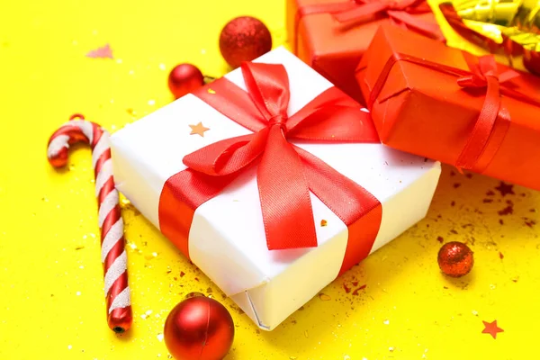 漂亮的圣诞礼物和黄色背景的装饰品 — 图库照片