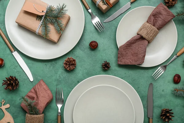 Schöne Tischdekoration Mit Weihnachtsgeschenk Und Tannenzapfen Auf Grünem Hintergrund — Stockfoto