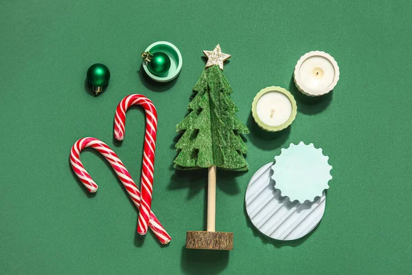 Díszítő Karácsonyfa Dobogókkal Gyertyákkal Cukornáddal Labdákkal Zöld Háttéren — Stock Fotó