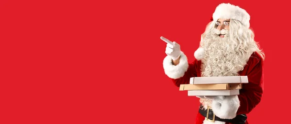 圣诞老人拿着装有美味披萨的盒子 指着红色背景上有文字空间的东西 — 图库照片