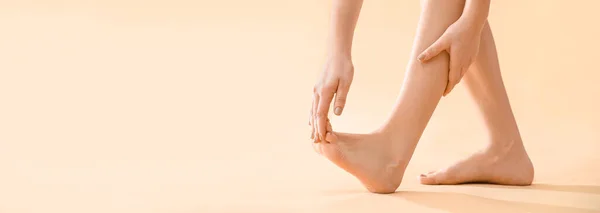 Junge Frau Macht Fußmassage Auf Beigem Hintergrund Mit Platz Für — Stockfoto