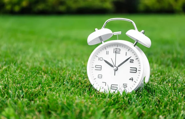 緑の芝生の上の白いヴィンテージ目覚まし時計 クローズアップ ストック写真