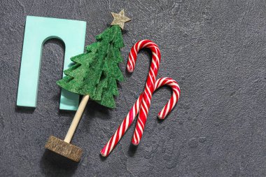 Karanlık arka planda podyum ve baston şekerlerle dekoratif Noel ağacı