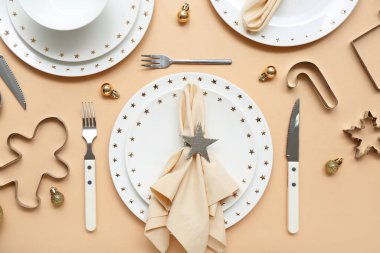 Noel topları ve bej arka planda kurabiye kesicilerle güzel bir masa.