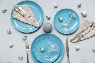 Mavi tabaklar ve gri arka planda Noel topları ile güzel bir masa.