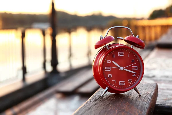 日の出に堤防上の赤いヴィンテージ目覚まし時計 クローズアップ — ストック写真