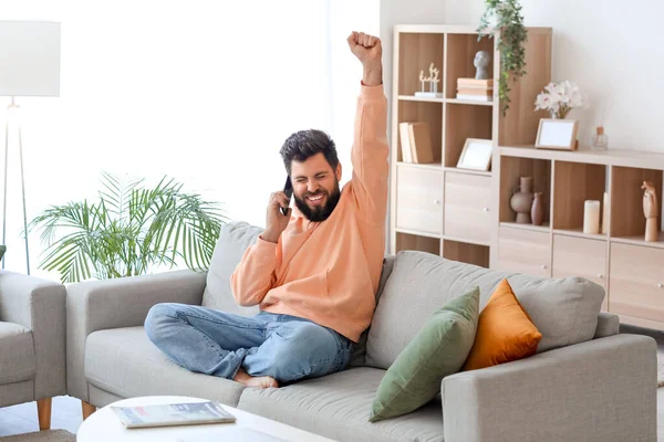 Happy Young Bearded Man Talking Mobile Phone Grey Sofa Home — Stock Photo, Image