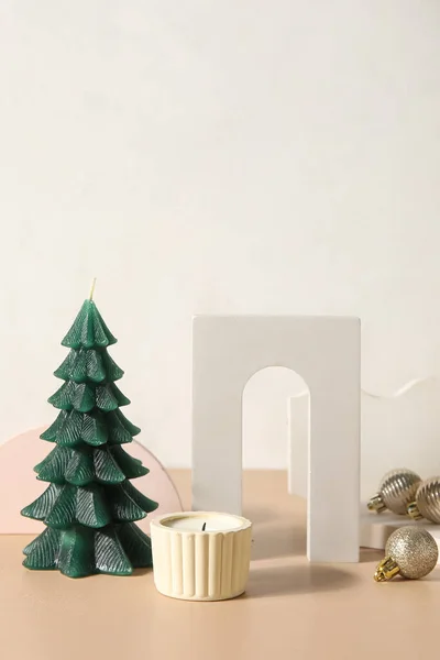 Weihnachtsbaumkerze Mit Podesten Und Kugeln Auf Tisch Neben Lichtwand — Stockfoto