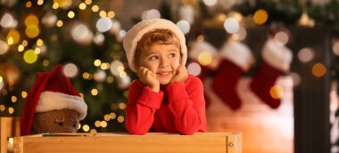 Evde Noel Baba 'ya mektup yazan şirin bir çocuk.