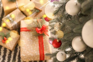 Güzel dekore edilmiş Noel ağacı ve altında bir sürü hediye kutusu, yakın plan.