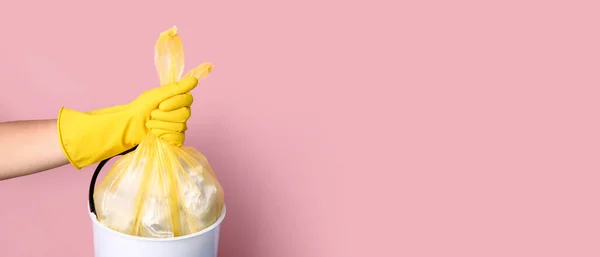 stock image Janitor taking bag with trash out of bin on pink background with space for text