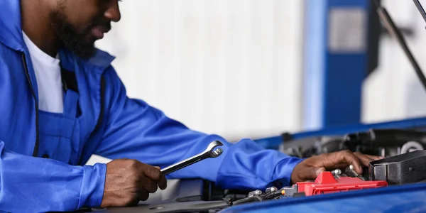 stock image African-American mechanic working in car service center, closeup