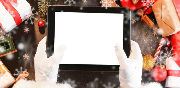Hands Santa Claus Med Surfplatta Dator Mörk Bakgrund Med Juldekor — Stockfoto