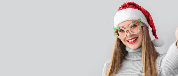 快乐的年轻女子戴着圣诞礼帽 带着灰色背景的自拍 有文字空间 — 图库照片