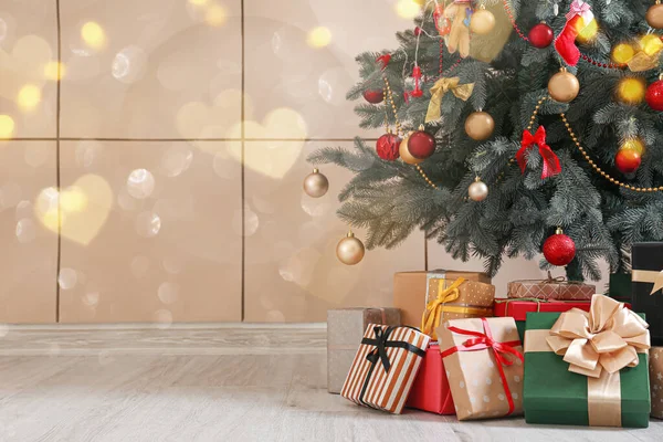 ベージュの壁の近くに飾られたクリスマスツリーとギフト — ストック写真